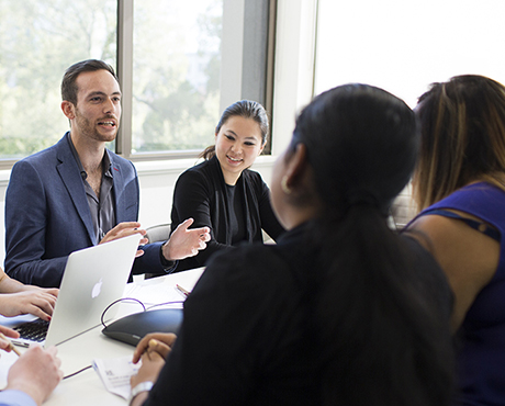 Photo of people sitting around table in meeting