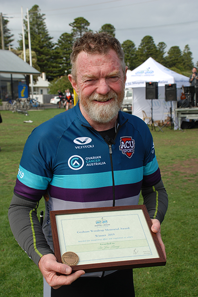 Joe holding Woody medal and plaque