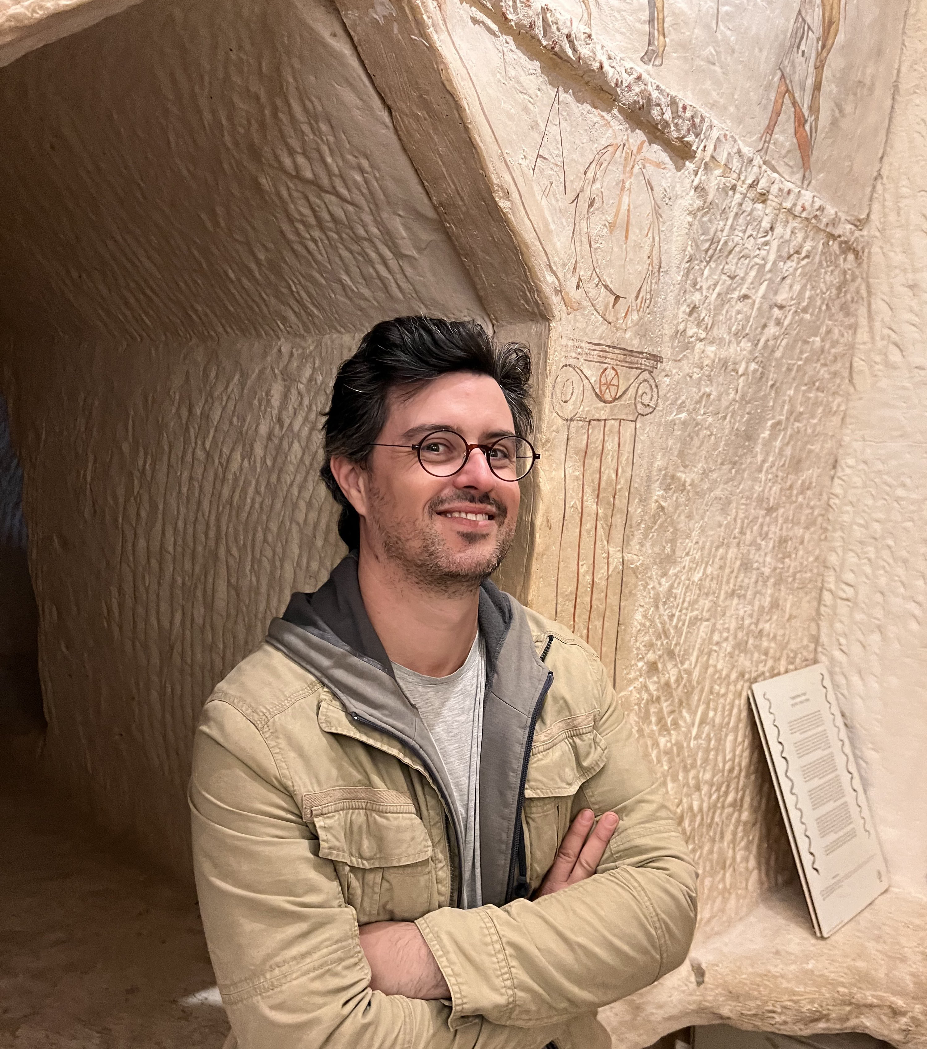  Dr Gareth Wearn a white man with brown hair and round glasses wearing a beige casual jacket at an historical site