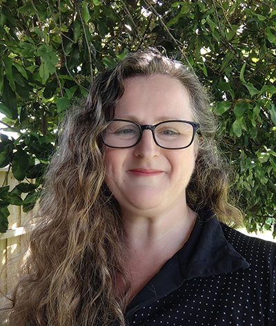  Louise Rogers a white woman with long wavy hair and glasses