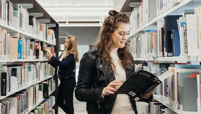 Woman in the library browsing a book.