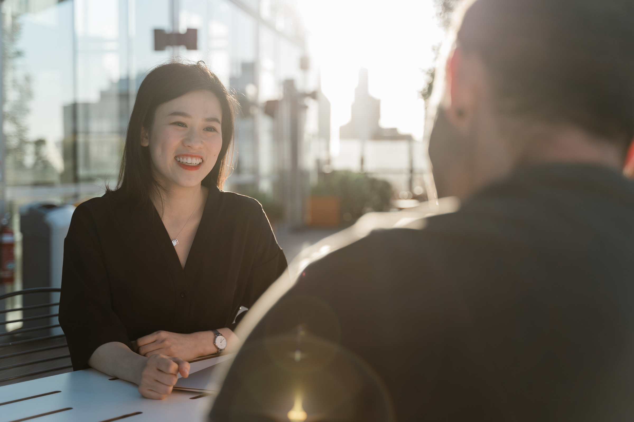  Lady sitting on the bench smiling while talking to another person
