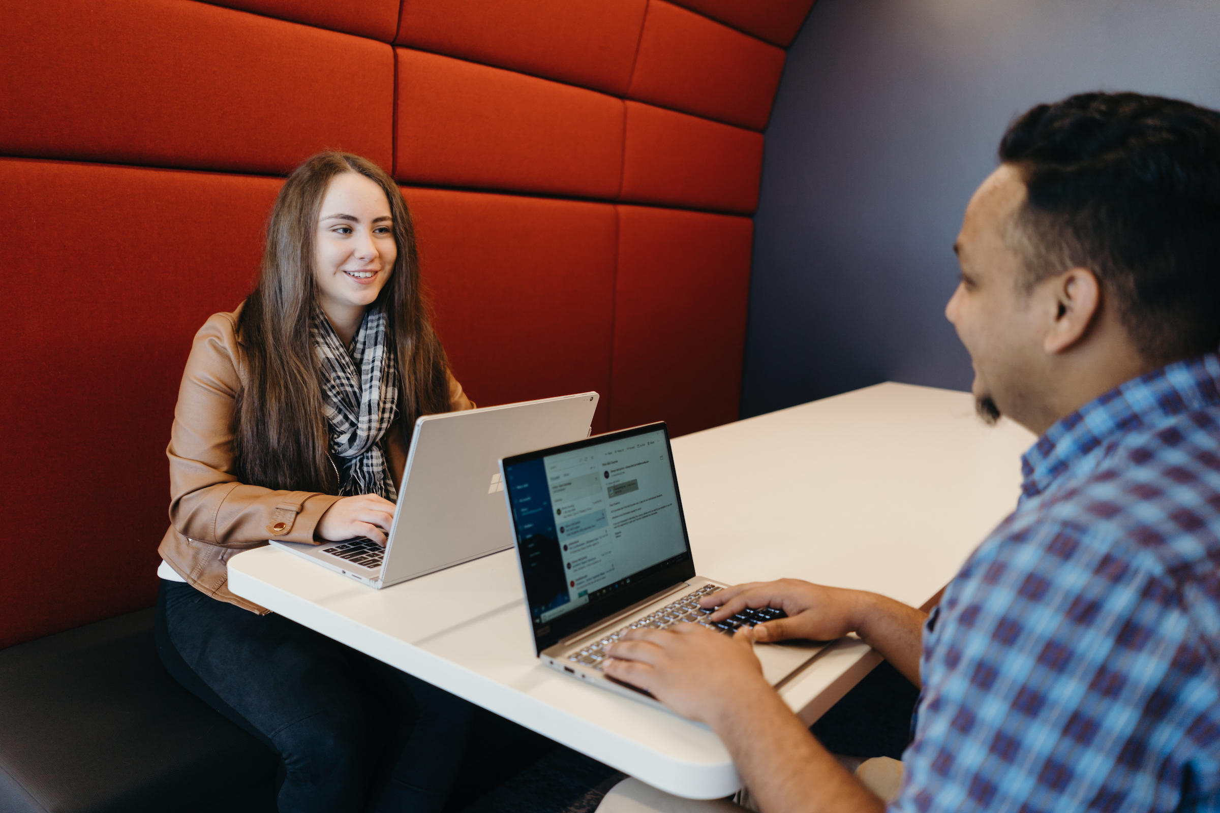 photo of Two lecturers talking while sitting in a library bench