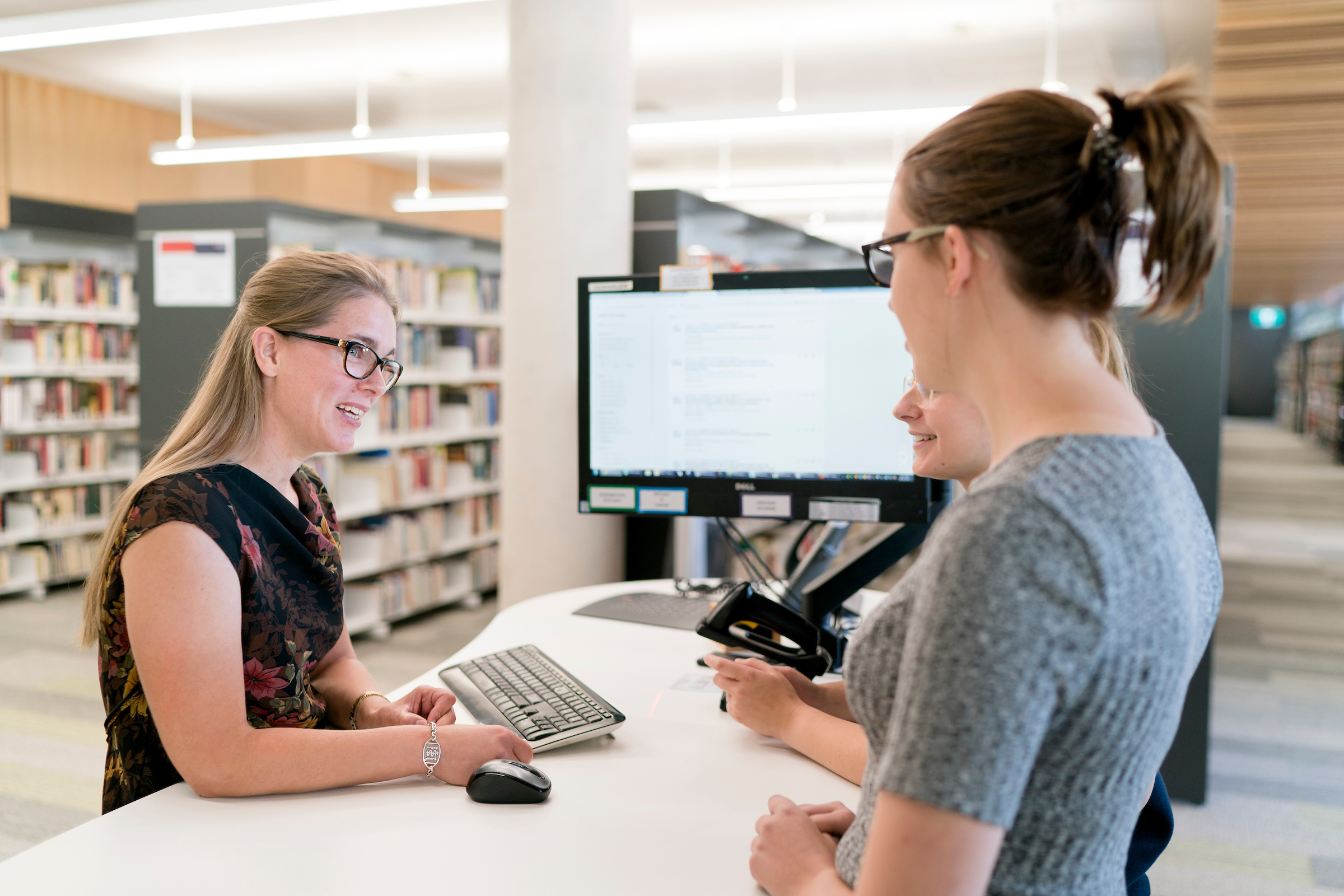 photo of library staff helping students